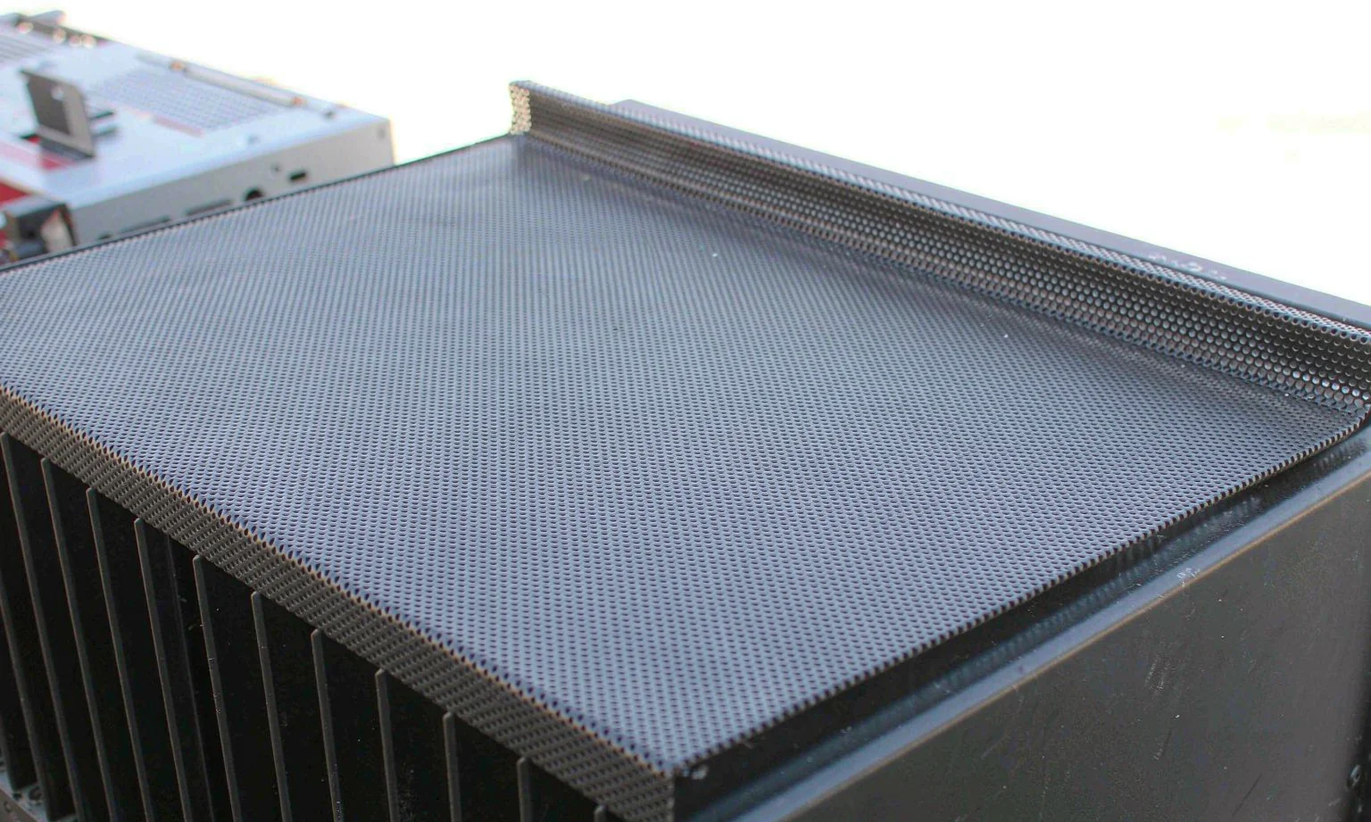 Perforated ventilation grille on top of an audio amplifier chassis