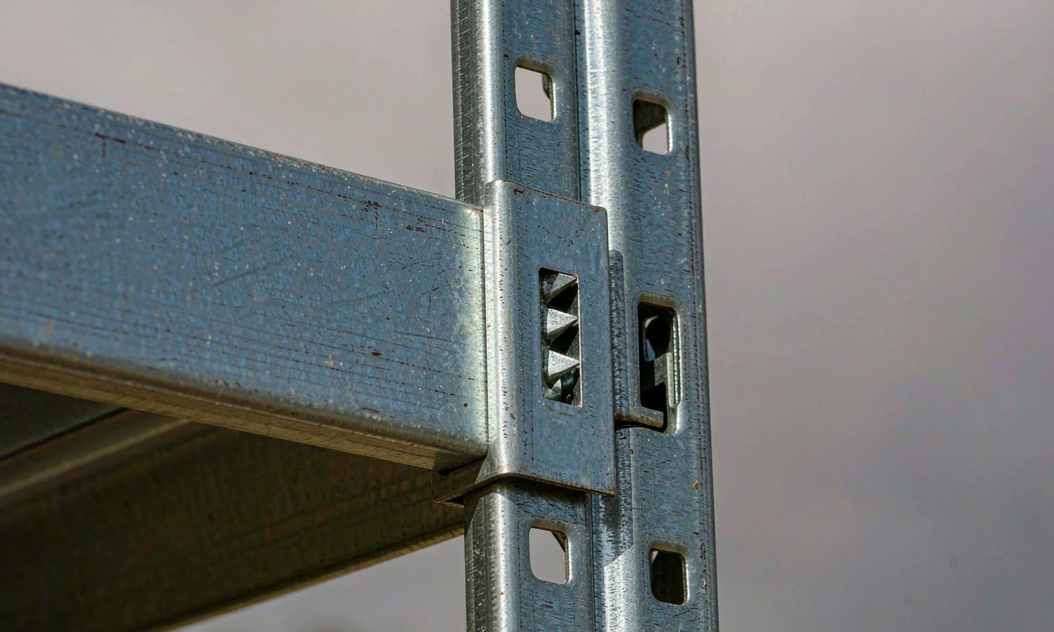 Boltless shelving beam connector in a punched upright