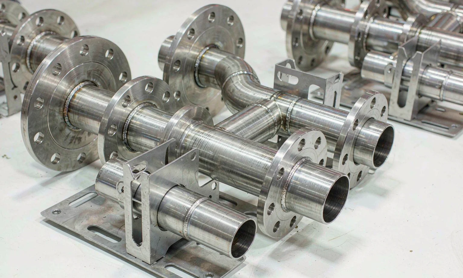 Stainless coolant manifold pipes in laser-cut mounting brackets