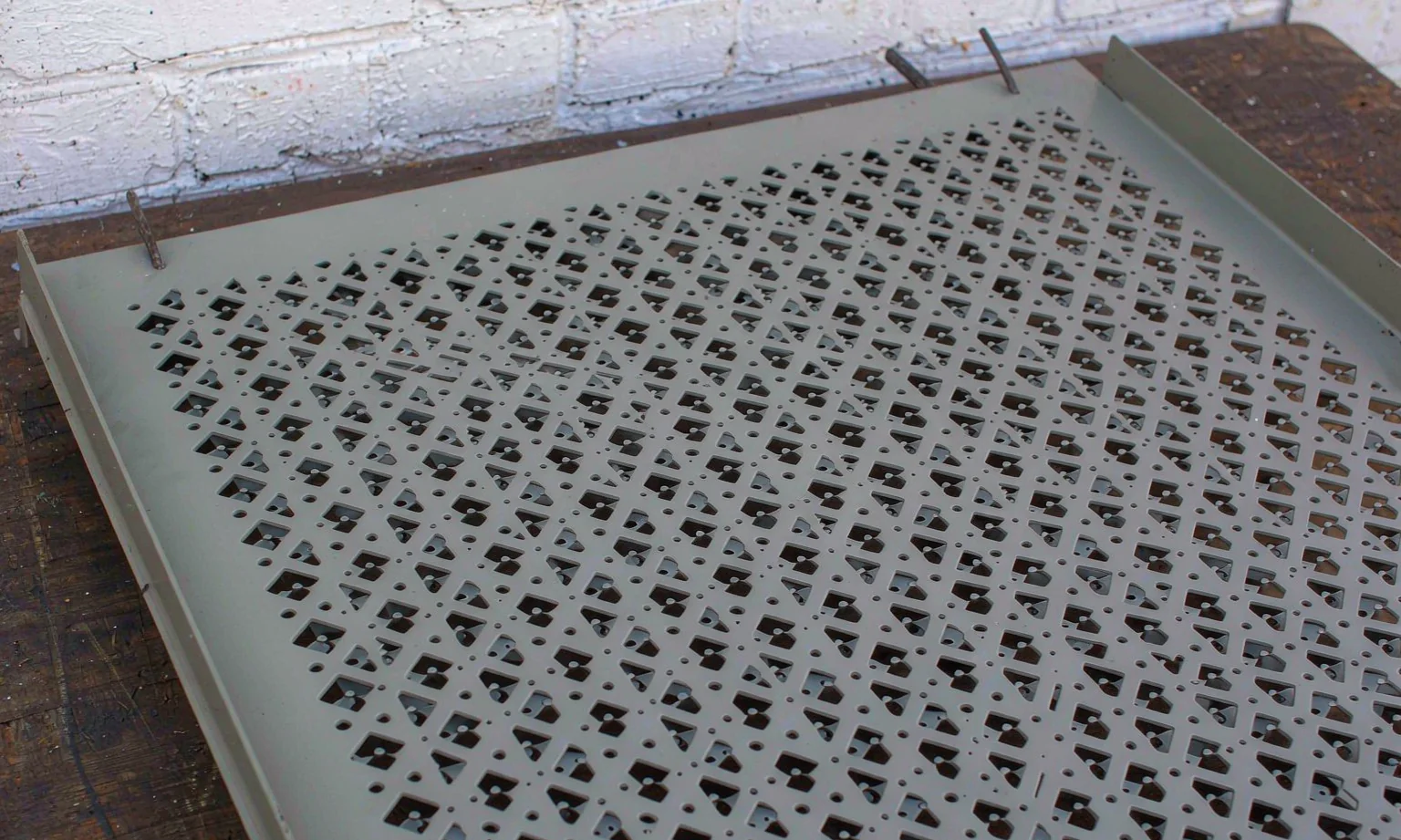 Powder-coated steel panel with punched ventilation pattern