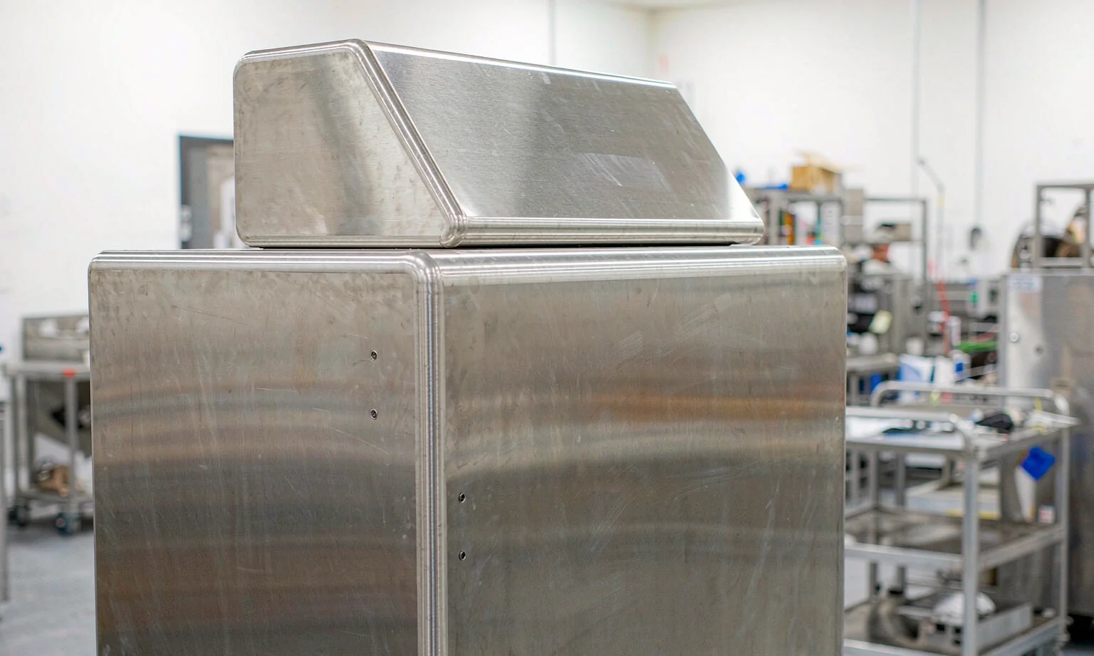 Brushed stainless steel medical equipment enclosure with rounded edges and sloped control panel