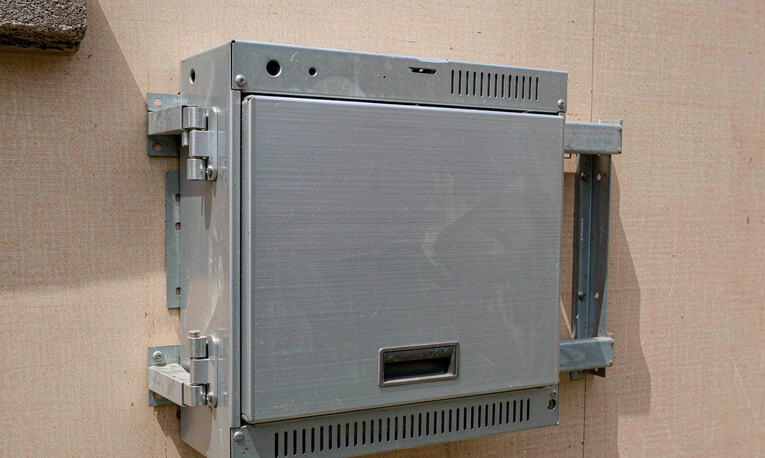 Wall-mounted industrial computer enclosure with brackets